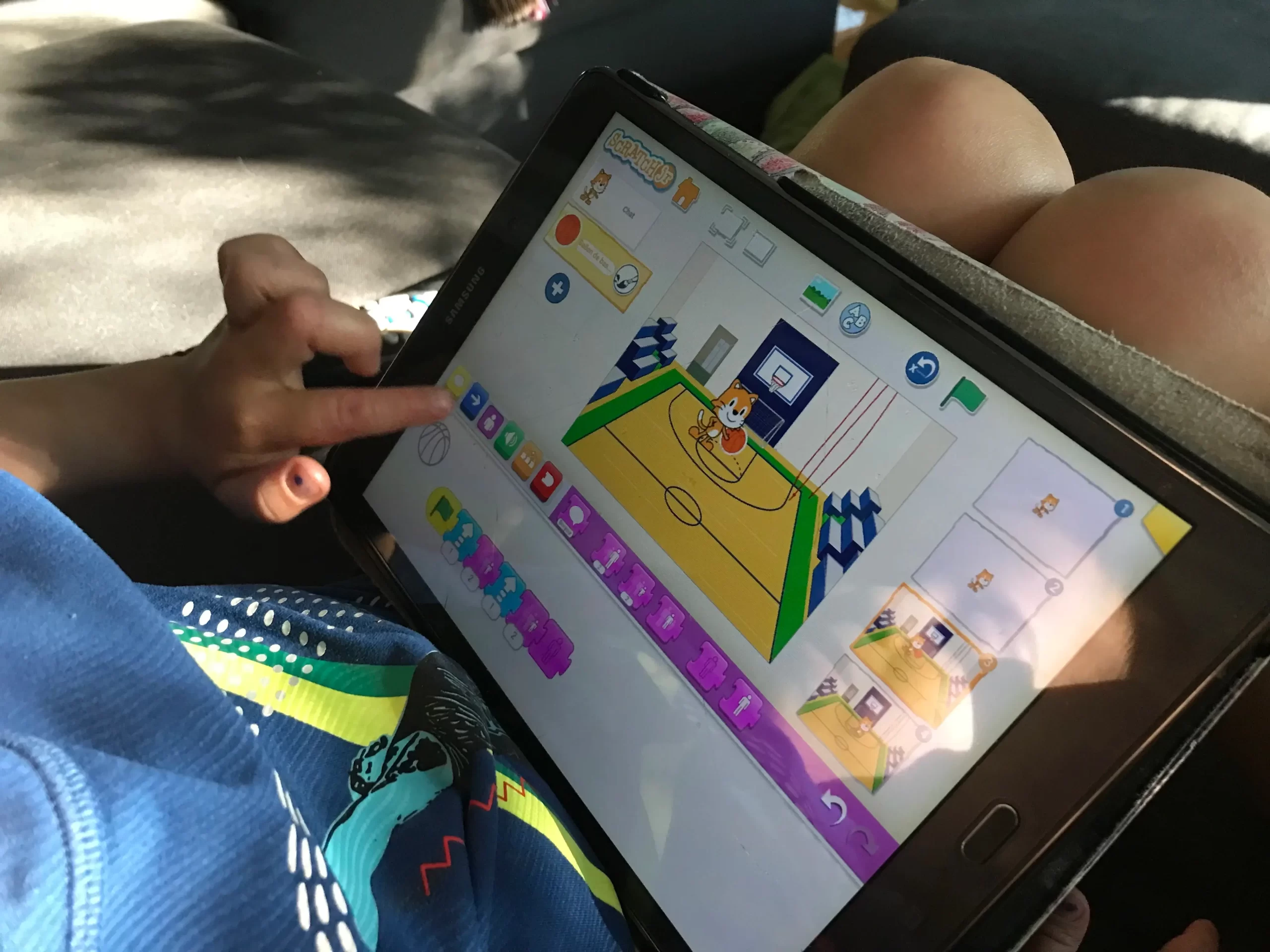 Jeune enfant joue avec des blocs de code sur Scratch Jr sur une tablette